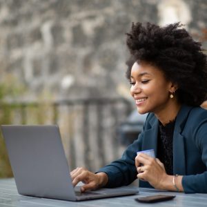 Portrait african american businesswoman sitting outside with laptop computer